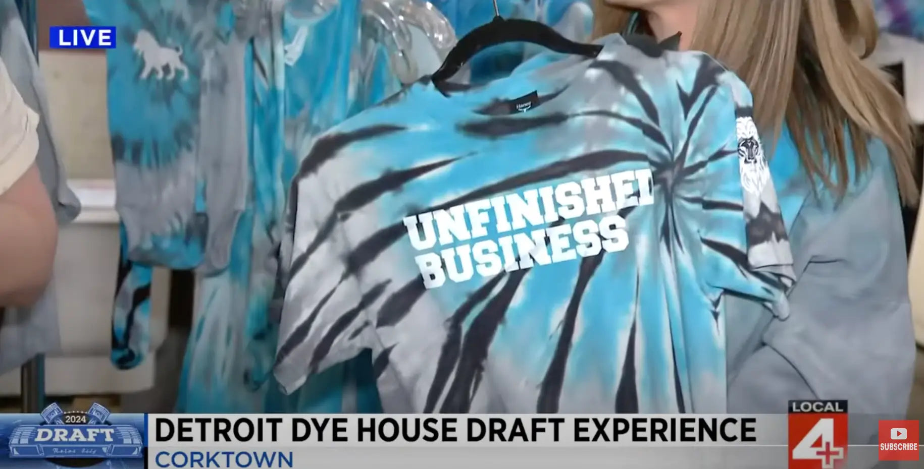 Tie-dyed t-shirt with UNFINISHED BUSINESS text at Detroit Dye House NFL Draft event