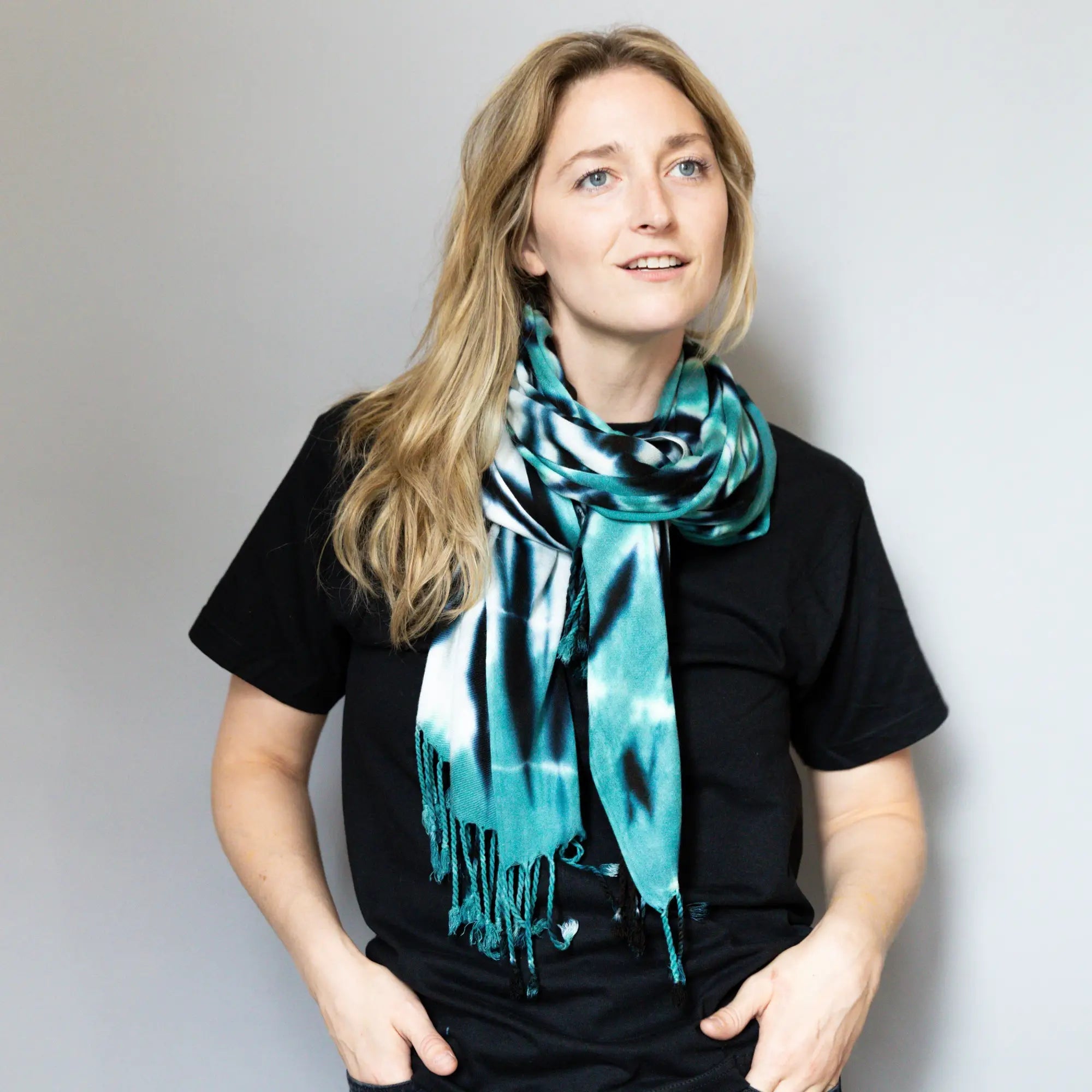 Vibrant turquoise and black tie dye silk scarf over a black t-shirt in Accessories collection.