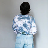 Back view of DDH Crew in blue and white tie dye sweatshirt with light wash jeans