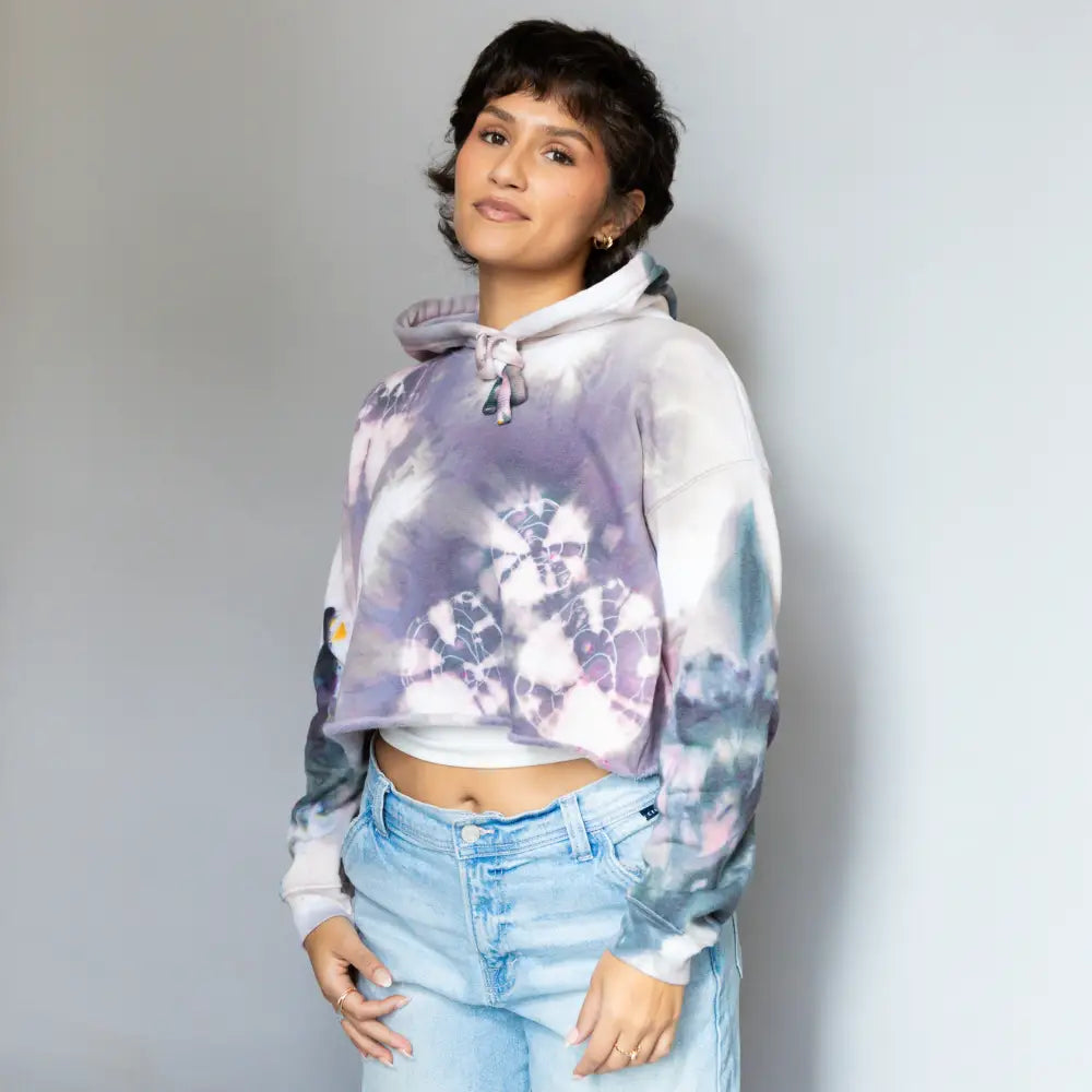 Cropped tie-dye hoodie styled with light blue jeans, perfect for trendy outfits