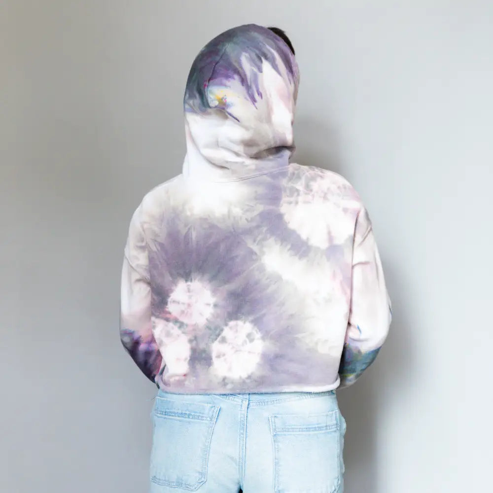 Tie-dyed white and purple DDH Crop Hoodie paired with light blue denim shorts