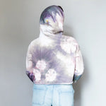 Tie-dyed white and purple DDH Crop Hoodie paired with light blue denim shorts