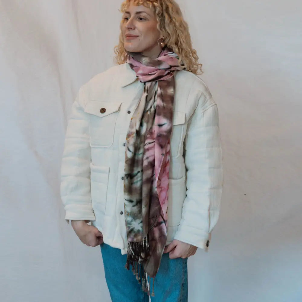 White winter jacket with front pockets paired with a vibrant pink tie dye scarf