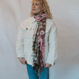 White winter jacket with front pockets paired with a vibrant pink tie dye scarf