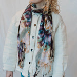 Tie-dye scarf with multicolored splotches on a white button-up jacket