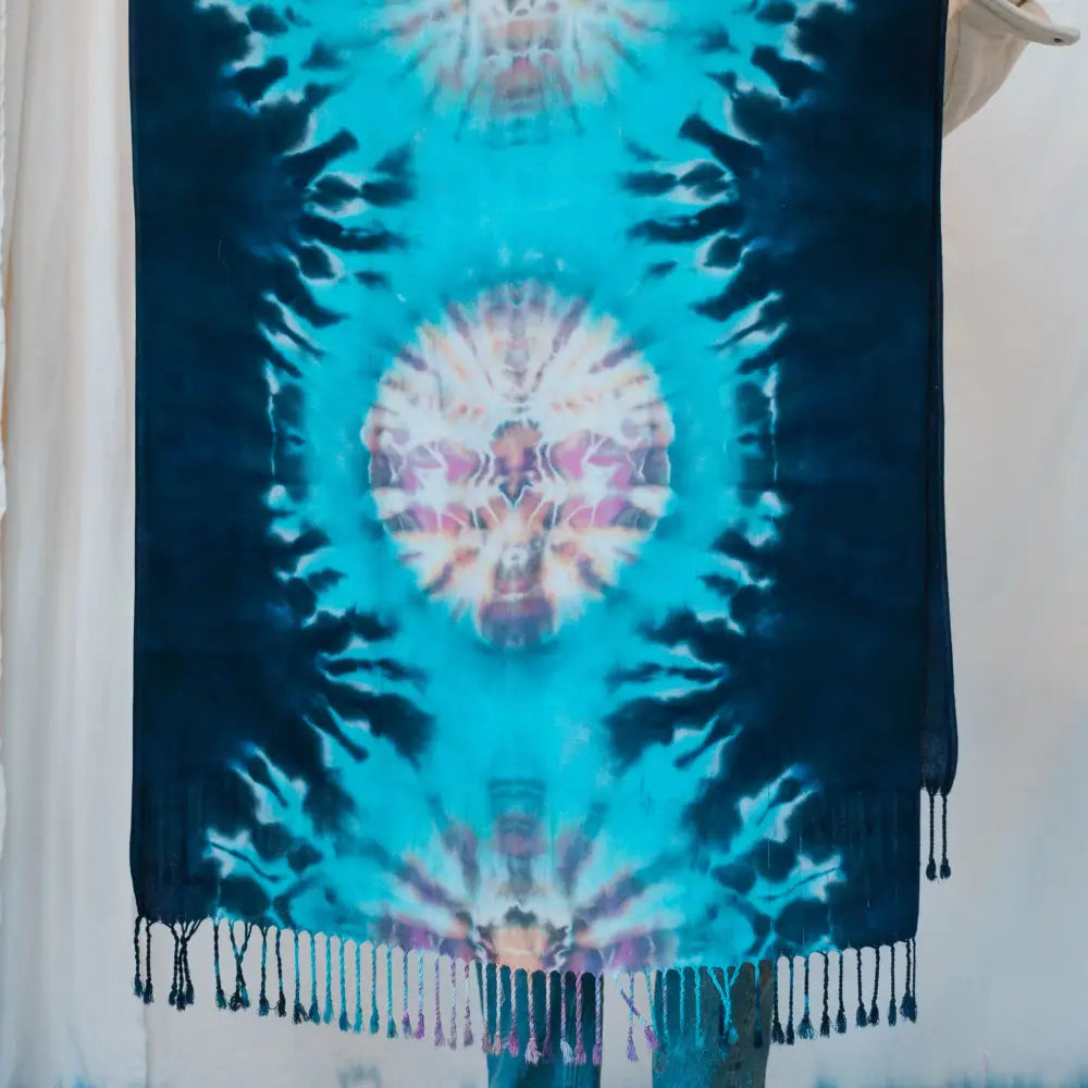 Tie-dyed blue and white scarf with tasseled fringe, a stylish clothing accessory