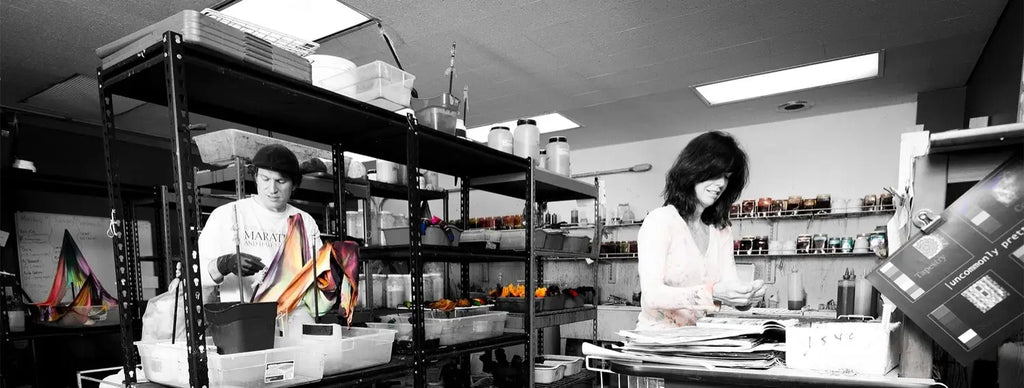 Black and white photo with selective color of people in a lab, showcasing Our Story art fair circuit.