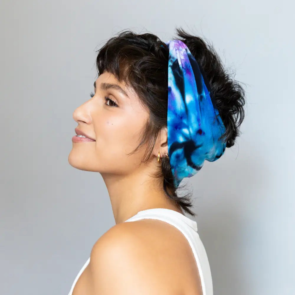 Vibrant blue and purple BrightlyTwisted headband features in dark hair display