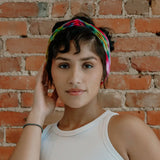 Colorful BrightlyTwisted headband features stylish patterns worn with a white tank top