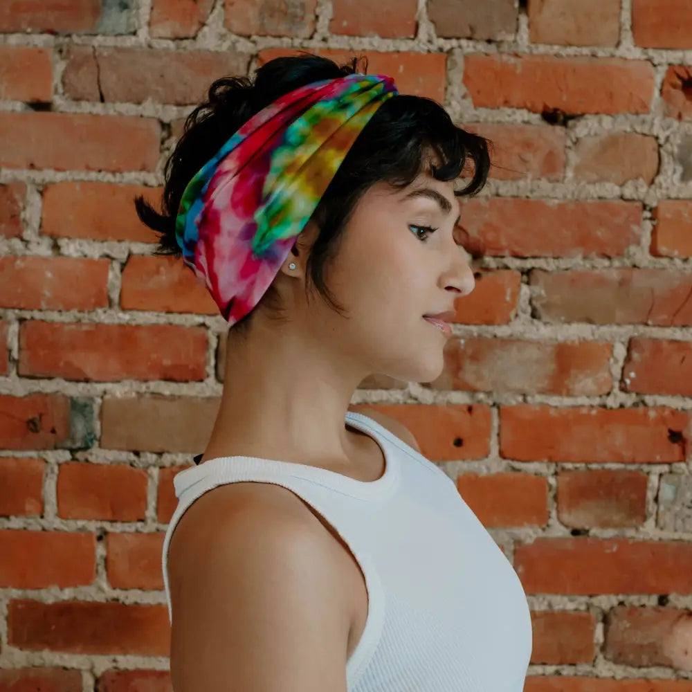 Vibrant BrightlyTwisted headband with rainbow colors worn with a white sleeveless top