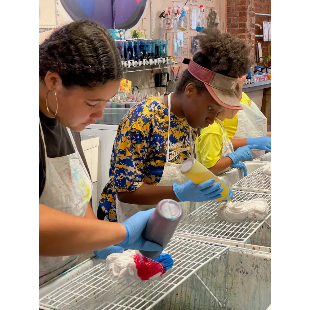 Two workers in gloves cleaning dishes at a CORKTOWN art studio for a birthday party