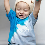 Joyful child in a beanie and blue Lions Kid Tee with a lion design