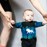 Baby in a tie dye union suit featuring a stylish white lion design