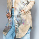 Kyle jacket featuring a tie-dyed beige design with pastel splotches over denim jeans