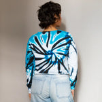 Tie-dyed crop crew sweatshirt in blue, black, and white with light denim jeans