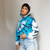 Blue and white tie dye crop hoodie with text paired with light wash jeans for casual clothing