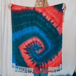 Stylish tie dye scarf featuring a red and blue spiral pattern with tassel fringe