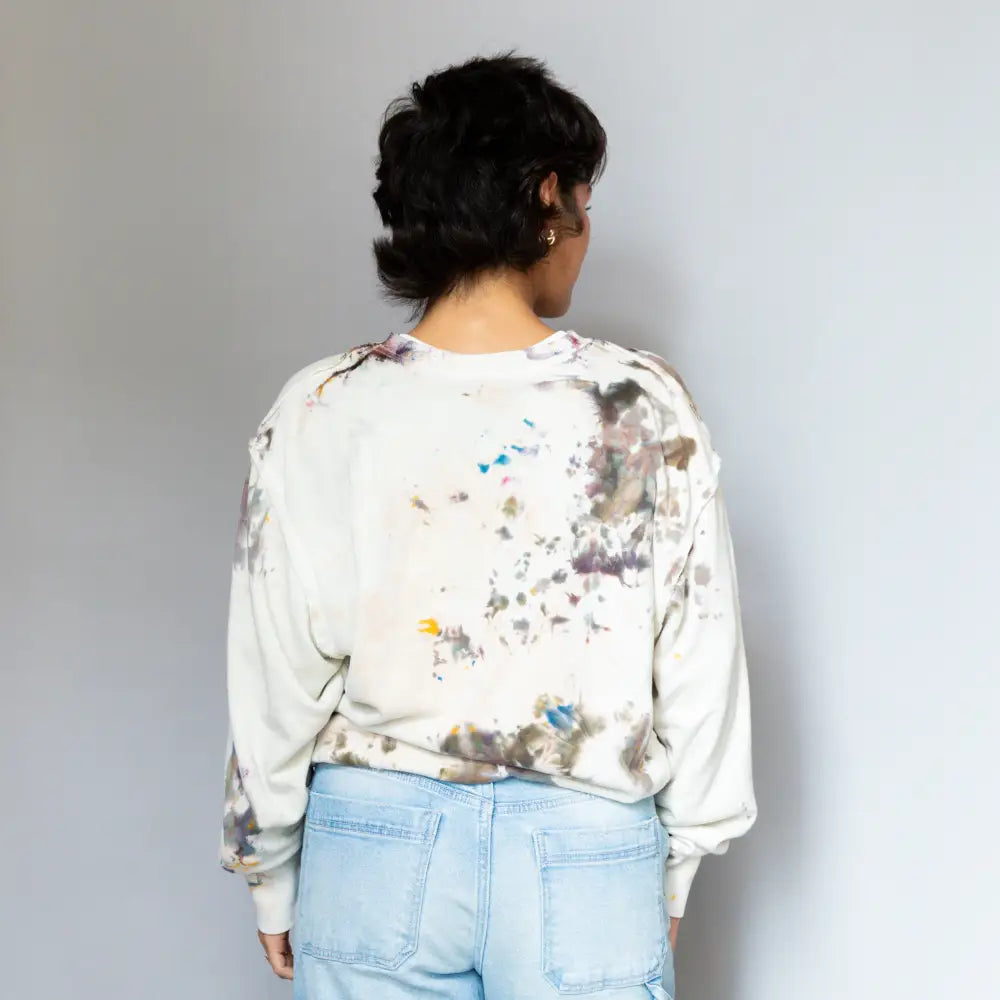 White Tammy crew sweatshirt worn backwards with abstract gray and colorful paint splatters