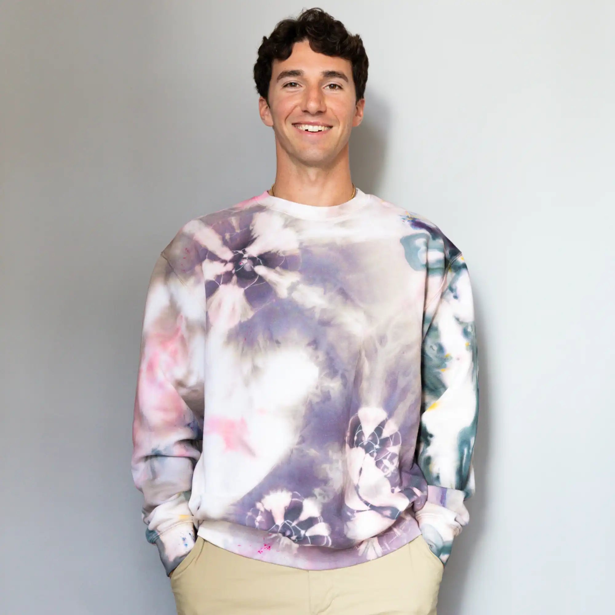 Tie-dyed sweatshirt with purple, pink, and blue watercolor-like patterns.