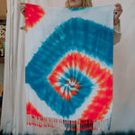 Tie-dye scarf in turquoise and coral red with spiral pattern and fringe detail