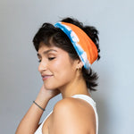 Colorful BrightlyTwisted headband featuring orange and blue design with white accents