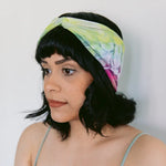 Brightlytwisted headband with vibrant yellow, blue, and pink tie-dye patterns