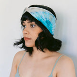 Tie-dyed turquoise and white BrightlyTwisted headband worn with dark hair