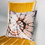 Tie-dyed velvet pillow with a spiral pattern in brown, white, and blue tones