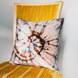 Tie-dyed velvet pillow with a spiral pattern in brown, white, and blue tones