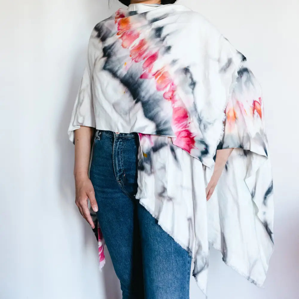 Tie-dyed white asymmetrical shirt with pink and black swirls styled as a wrap