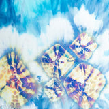 Tie-dyed scarf featuring diamond patterns in blue, yellow, and purple colors